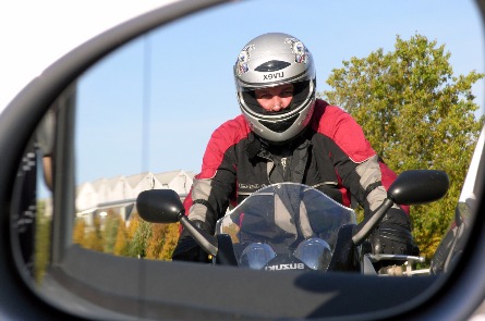 Blick in den Seitenspiegel auf einen Fahrschüler auf dem Motorrad.